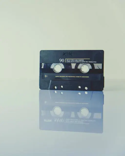 A black cassette tape standing on a pale surface
