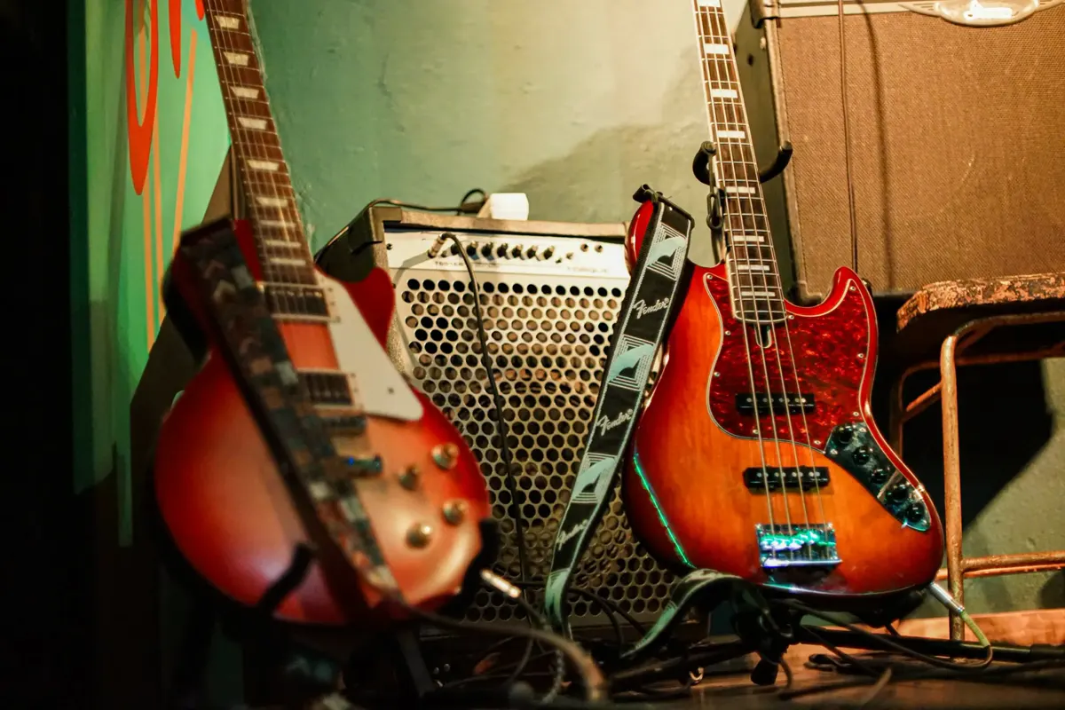 Two electric guitars leaning on an amp backstage