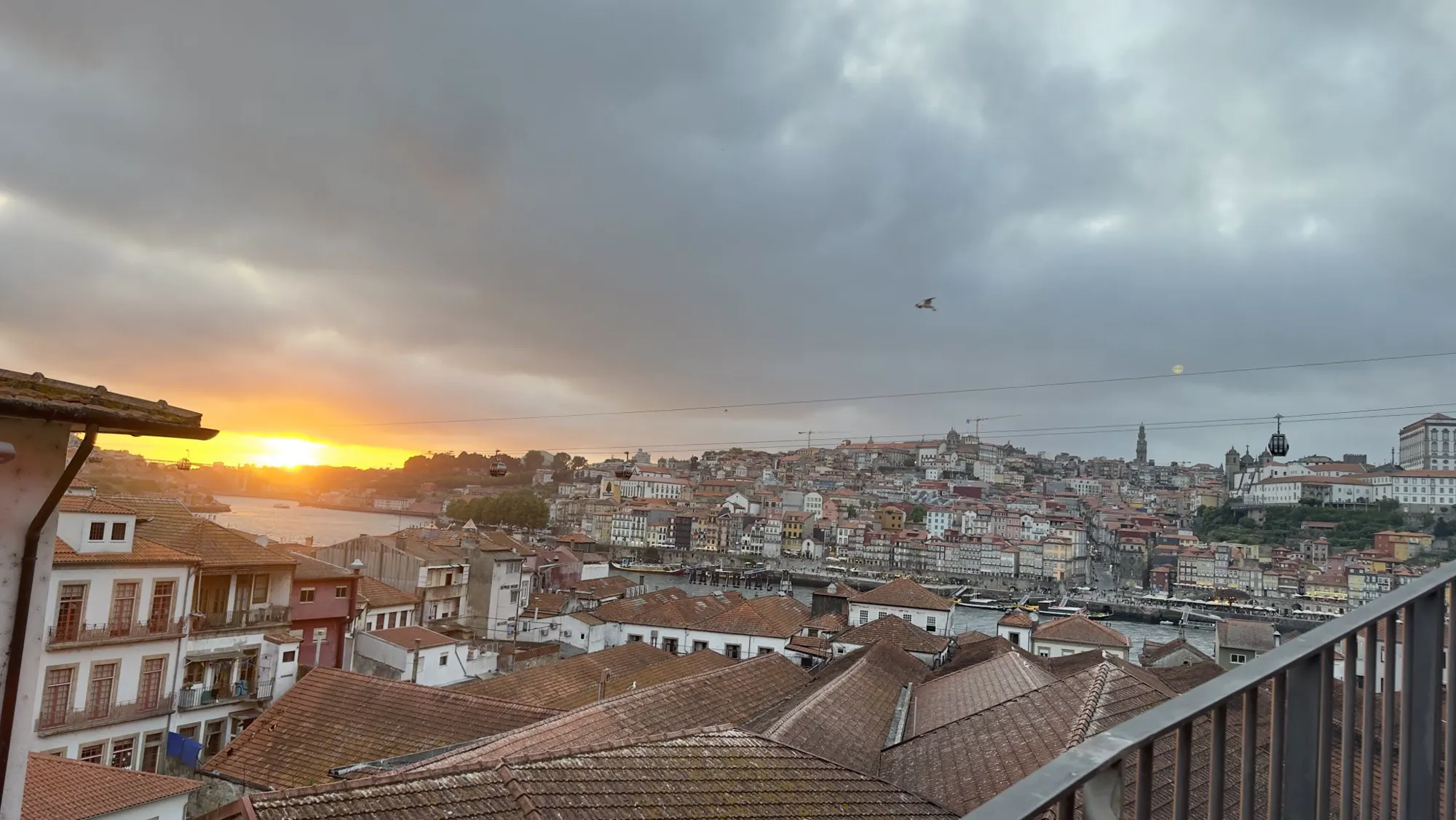 Tiled roofs falling away to the river at sunset, seen from a high window