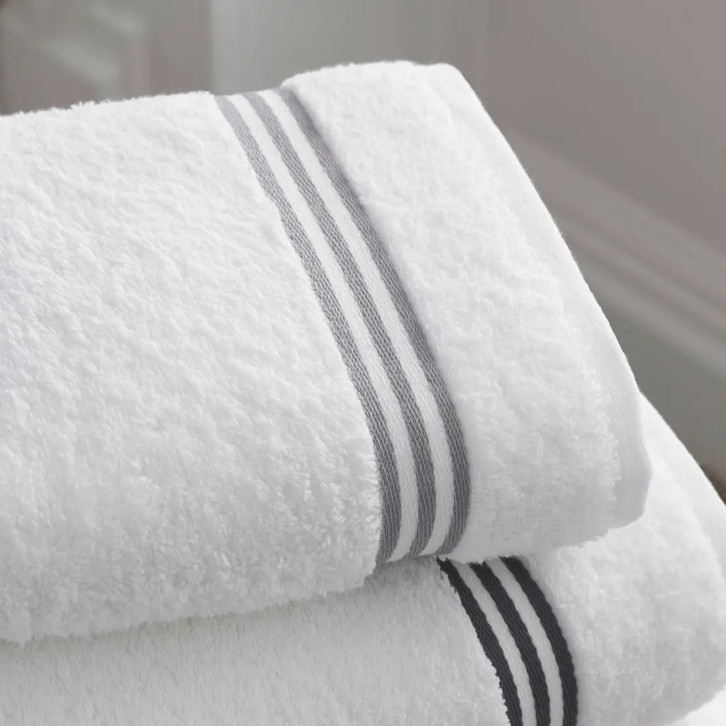 Folded white towels with a grey woven stripe